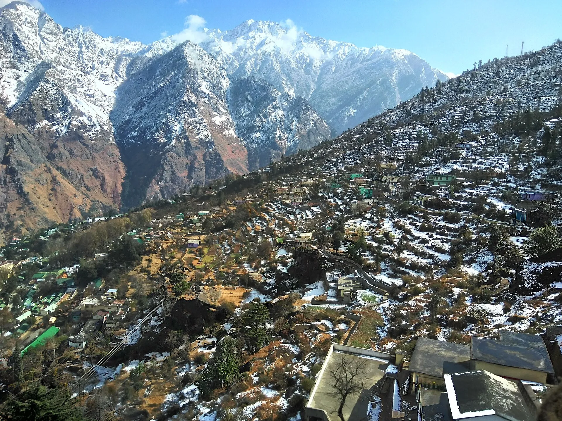 Snow-dusted Auli hillside and Himalayan peaks under a clear sky